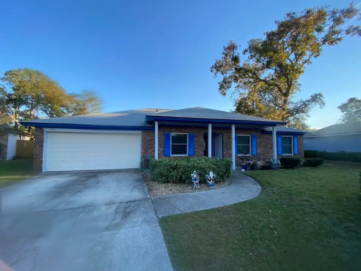 Single-story brick home with bright blue shutters and a white garage door