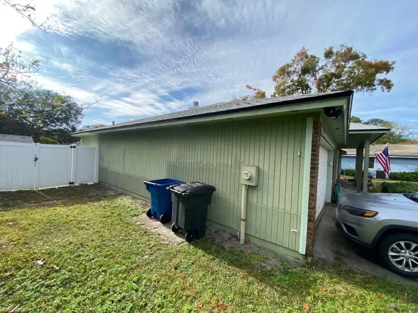 Green-painted side wall and trim beside a white backyard gate