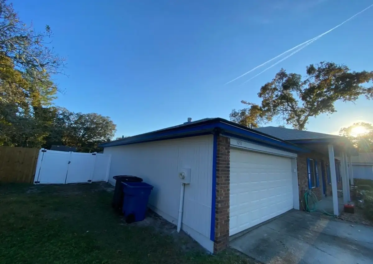 White-painted side exterior and garage with bright blue trim