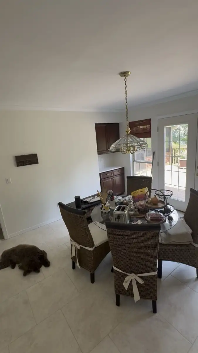 Completed dining room with light painted walls, white crown molding, and French doors