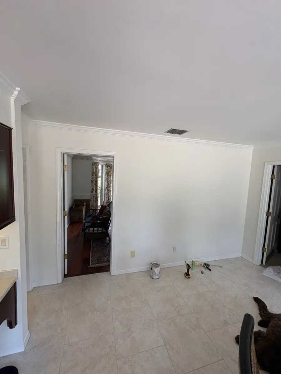 Completed kitchen wall detail with a smooth light finish and white crown molding