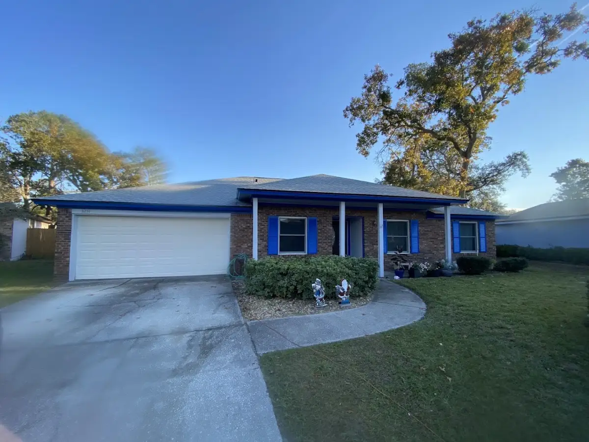 Brick home exterior with blue shutters viewed from the driveway